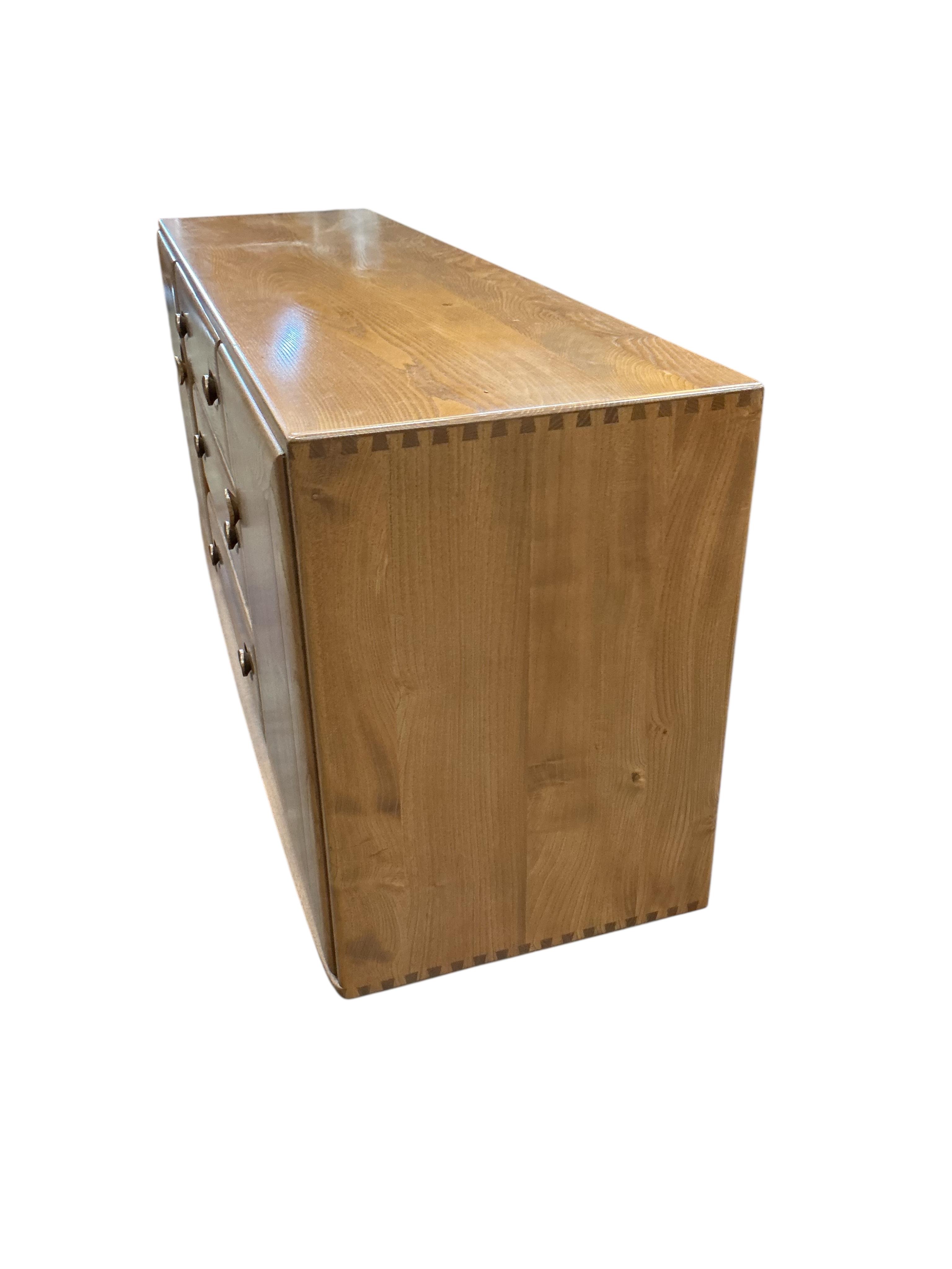 An Ercol Windsor elm sideboard, width 155cm, depth 43cm, height 69cm